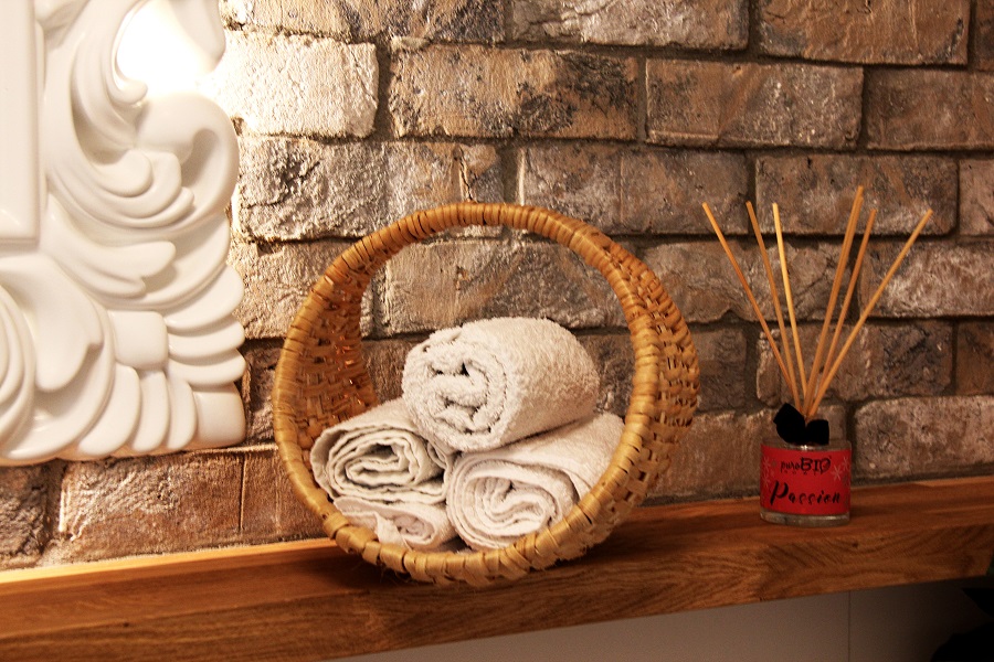 plecionka z korzenia sosny w łazience z klasycznymi elementami – zapasowe ręczniki w koszyku